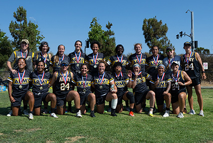 Wearing a pink ribbon in her hair, Navy Ensign Megan Neyen leads a huddle of rugby players from all services in a cheer ‘For Those Who Can’t’ at the conclusion of the 2024 Armed Forces Women’s Rugby Championships in San Diego, Calif. July 13, 2024. Team Army wore the motto “For Those Who Can’t’ on their uniforms to honor injured or deceased female service members. (DoD photo by EJ Hersom)